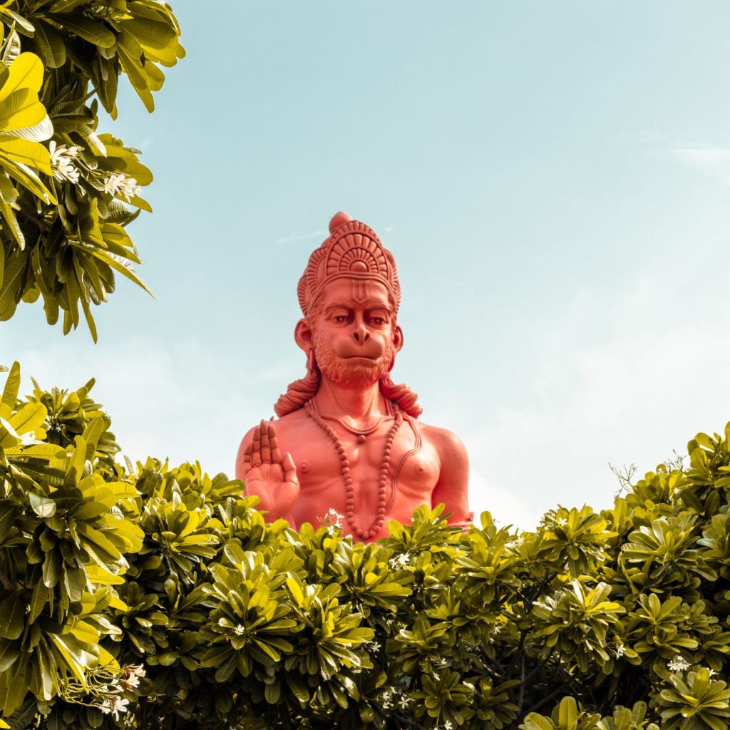 A glowing Hanuman statue with festive lights.