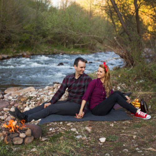 A couple dressed in winter clothes gazing into each other's eyes with the Eiffel Tower in the background.