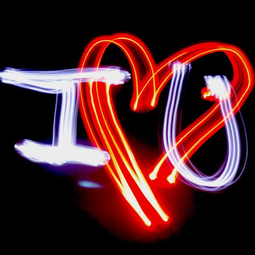 A creative light painting of the words "I ❤️ U" in bright red, blue, and white lights against a dark background, representing love and affection.