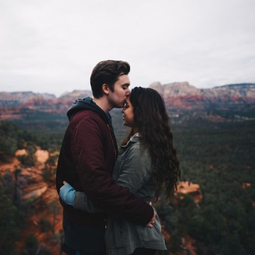 A couple embraces during their engagement session in the scenic red rock landscape of Sedona, Arizona