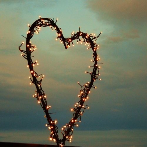 A heart-shaped light made of twigs, glowing softly against a dark background