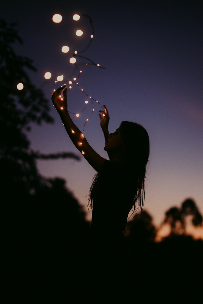 A woman holds up string lights against a dusky sky, creating a warm and inviting atmosphere