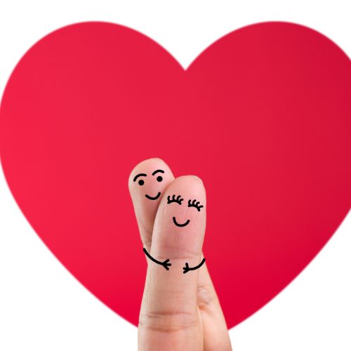Happy couple holding hands, forming a heart shape with their fingers