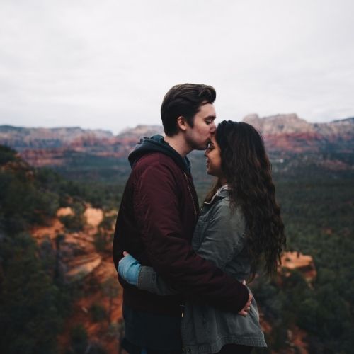 A couple embraces during their engagement session in the scenic red rock landscape of Sedona, Arizona
