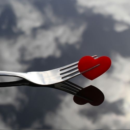 A silver fork with a heart-shaped handle, symbolizing love and affection in dining