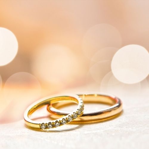 Two wedding rings resting on a table, with a softly blurred background enhancing their elegance