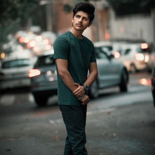A young man stands on the street