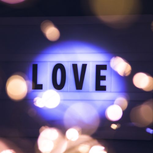 A decorative love lightbox surrounded by soft bokeh lights