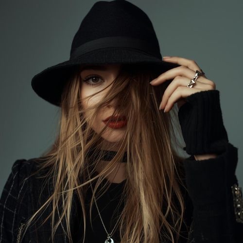 A woman with long hair wearing a stylish hat
