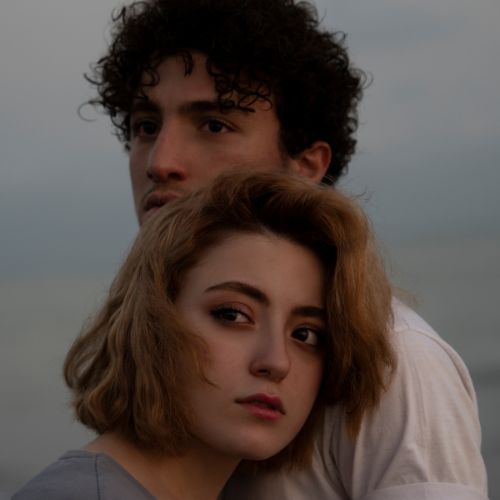 A young man and woman stand side by side