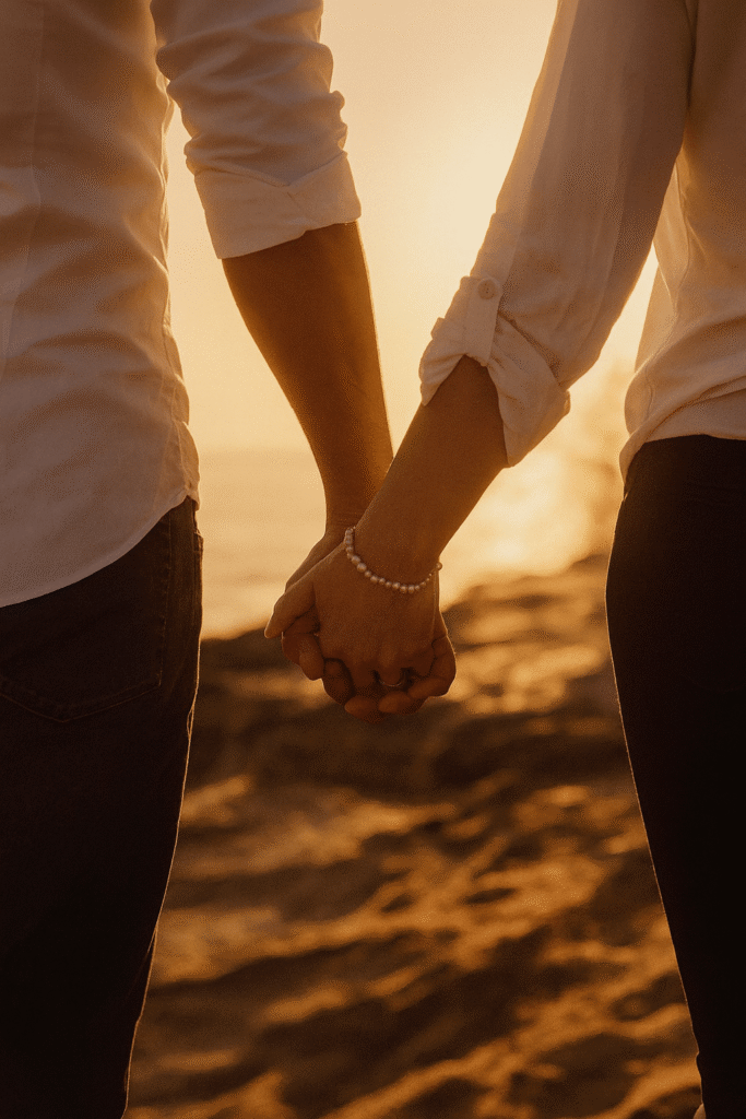A couple holding hands on the beach-min