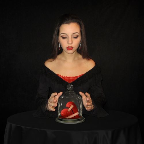 A woman holds a heart encased in a glass dome
