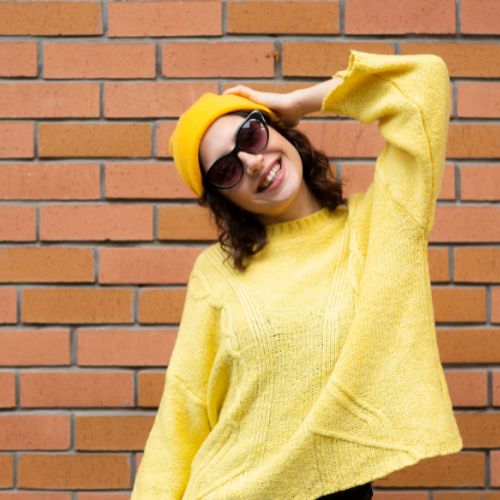 A woman wearing a yellow sweater