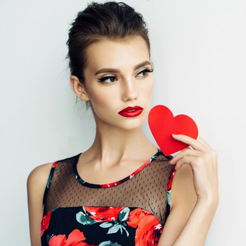 Beautiful woman with red lipstick holding a heart